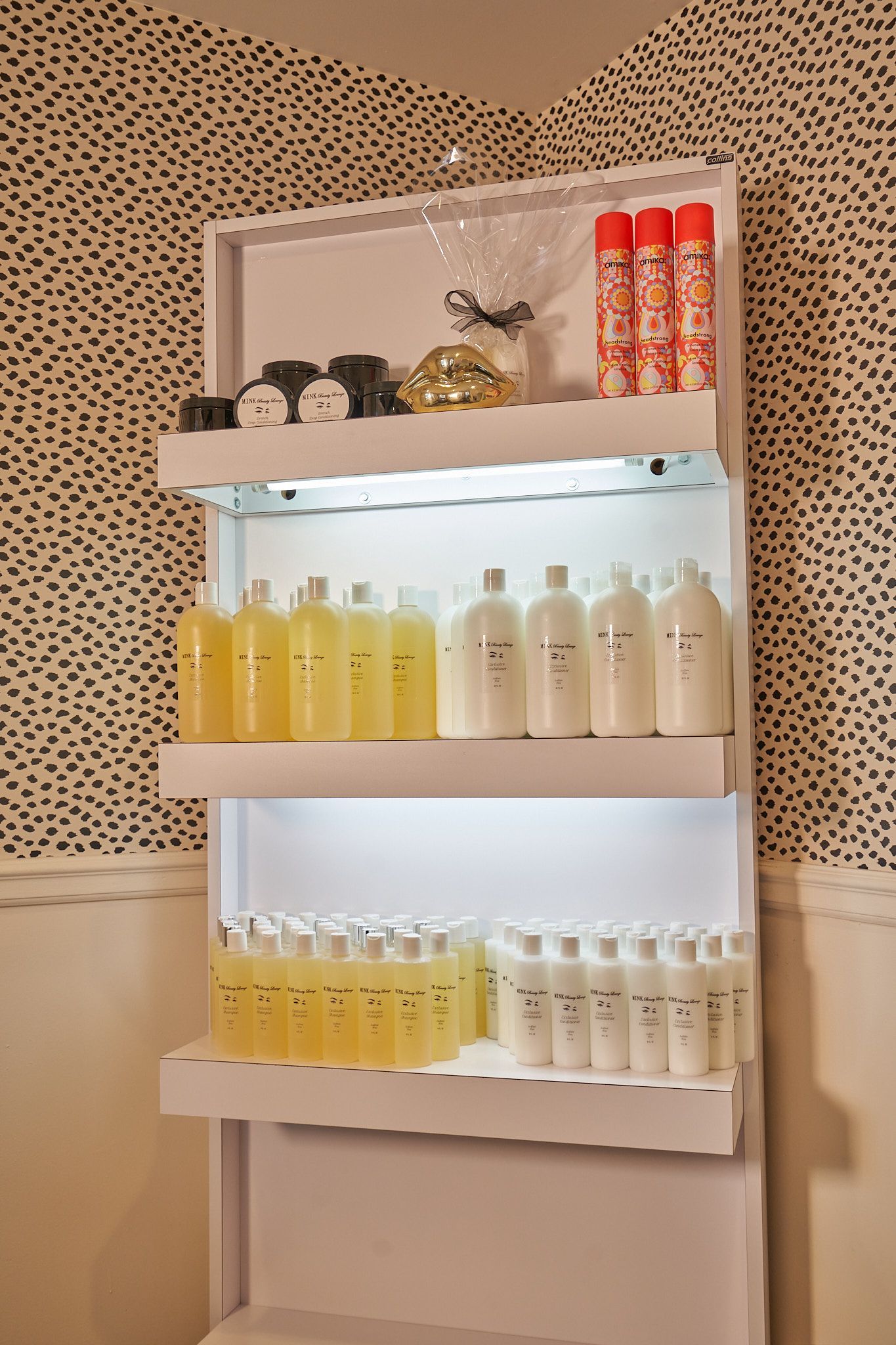 A shelf filled with bottles of shampoo and conditioner in a bathroom.