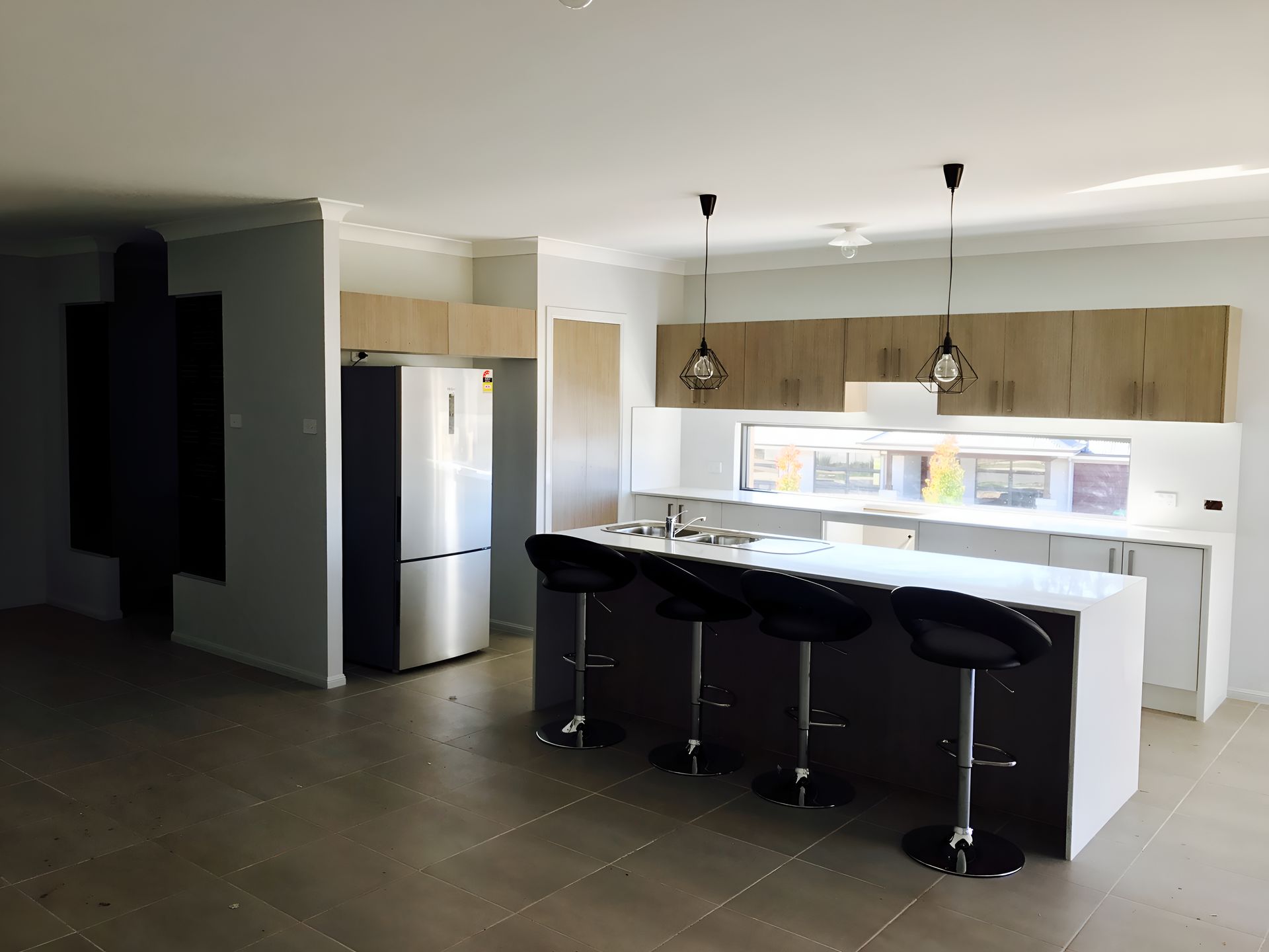 A Kitchen With a Large Island, Stools and a Refrigerator — Tefa Kitchens & Joinery in Rutherford, NSW