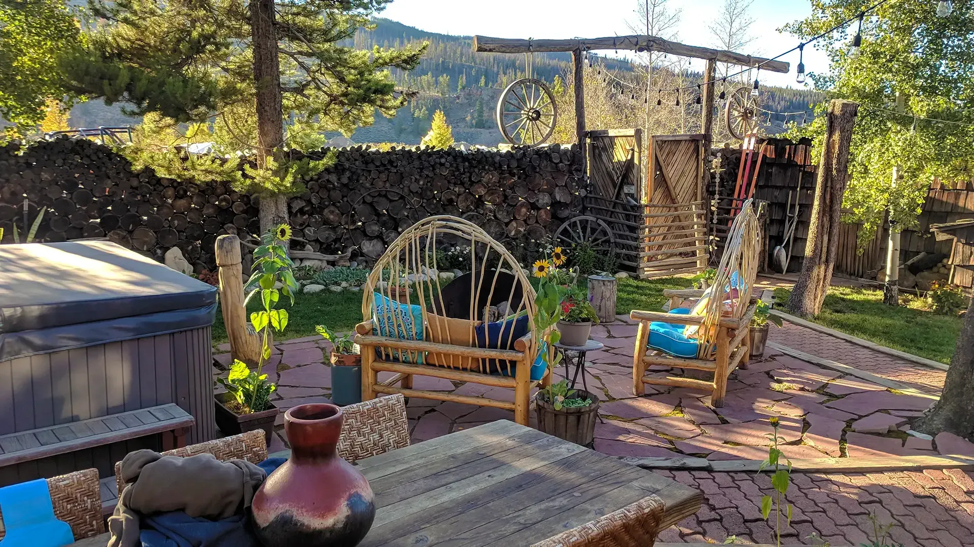 A patio with a table , chairs , and a hot tub.