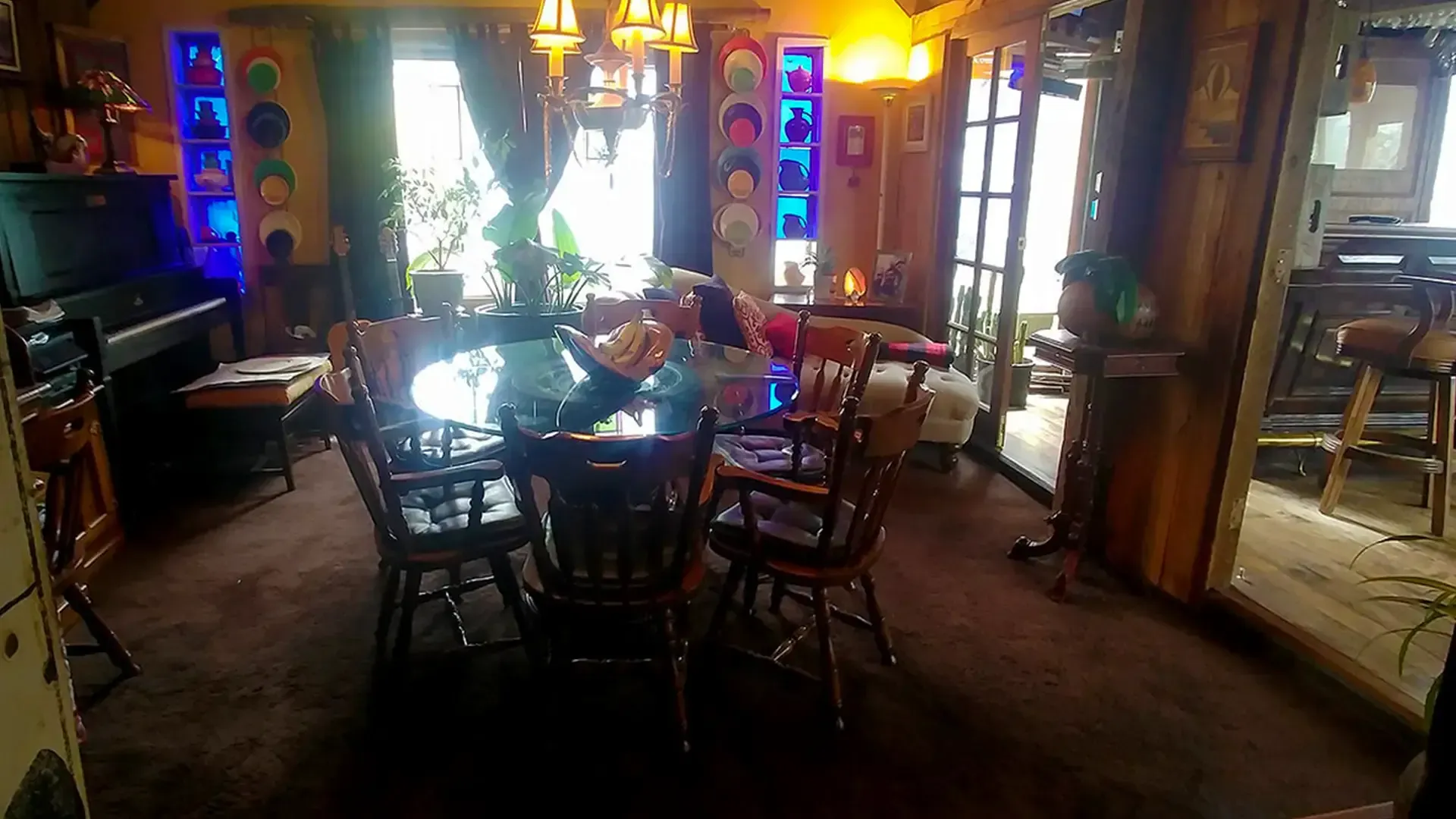 A large dining room with a table and chairs and a piano.