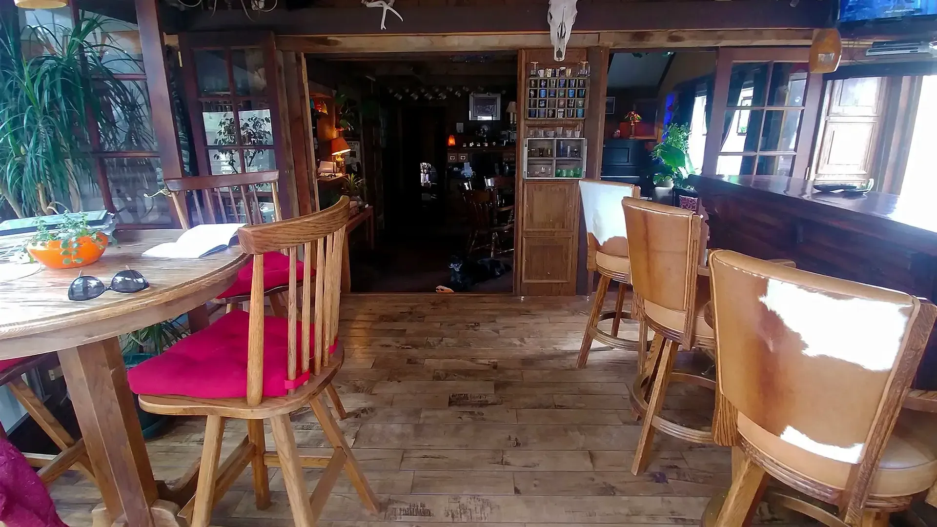 A wooden room with a table and chairs in it