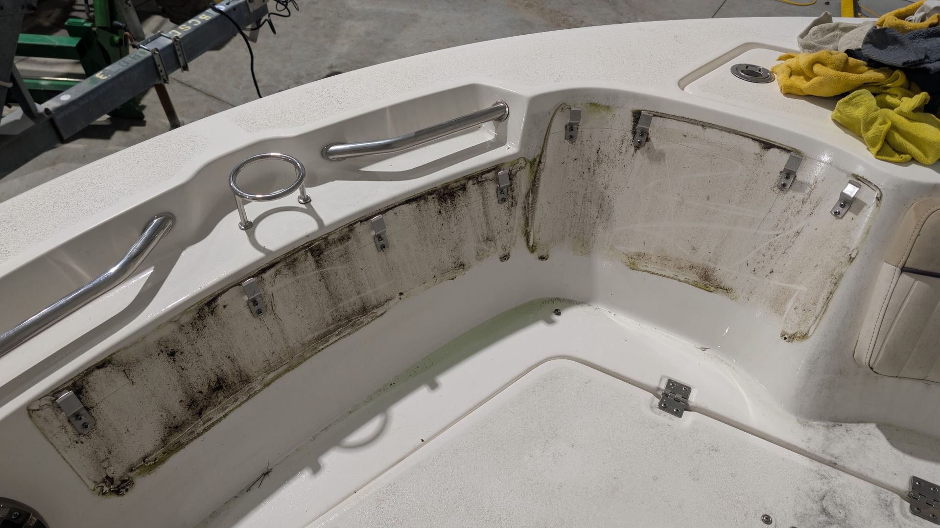 Dirty white boat seating area with black mold stains and a yellow cloth on the right