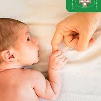 Una mano che tiene delicatamente le piccole dita di un neonato su uno sfondo bianco e soffice.