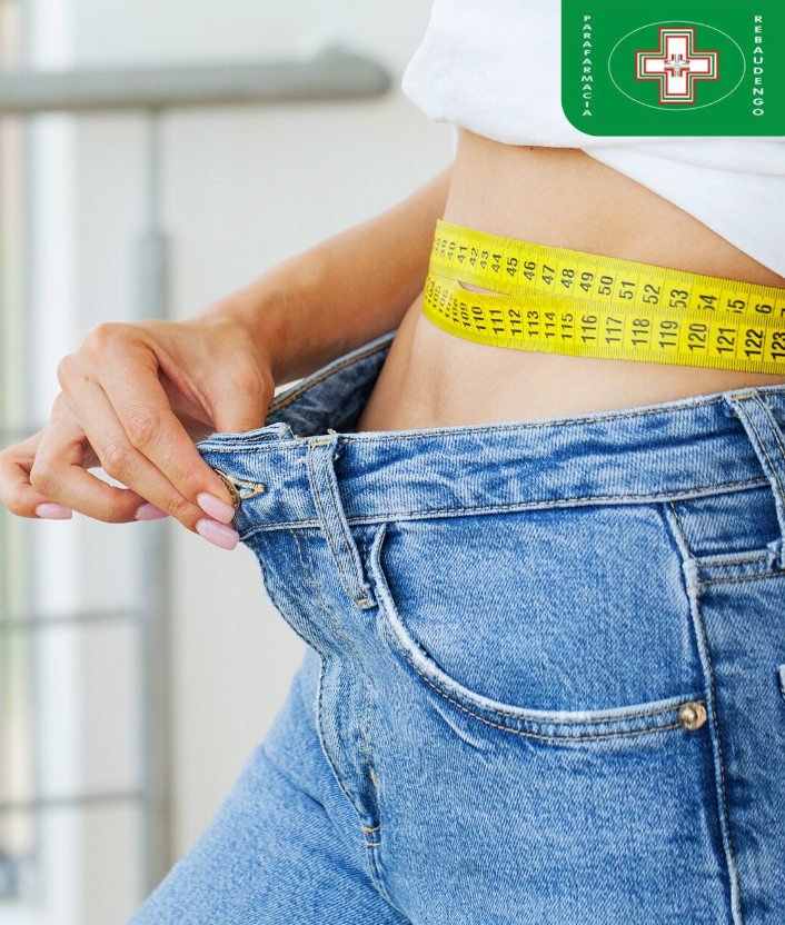 Una persona che indossa jeans larghi e un metro a nastro giallo intorno alla vita, a simboleggiare una perdita di peso riuscita.