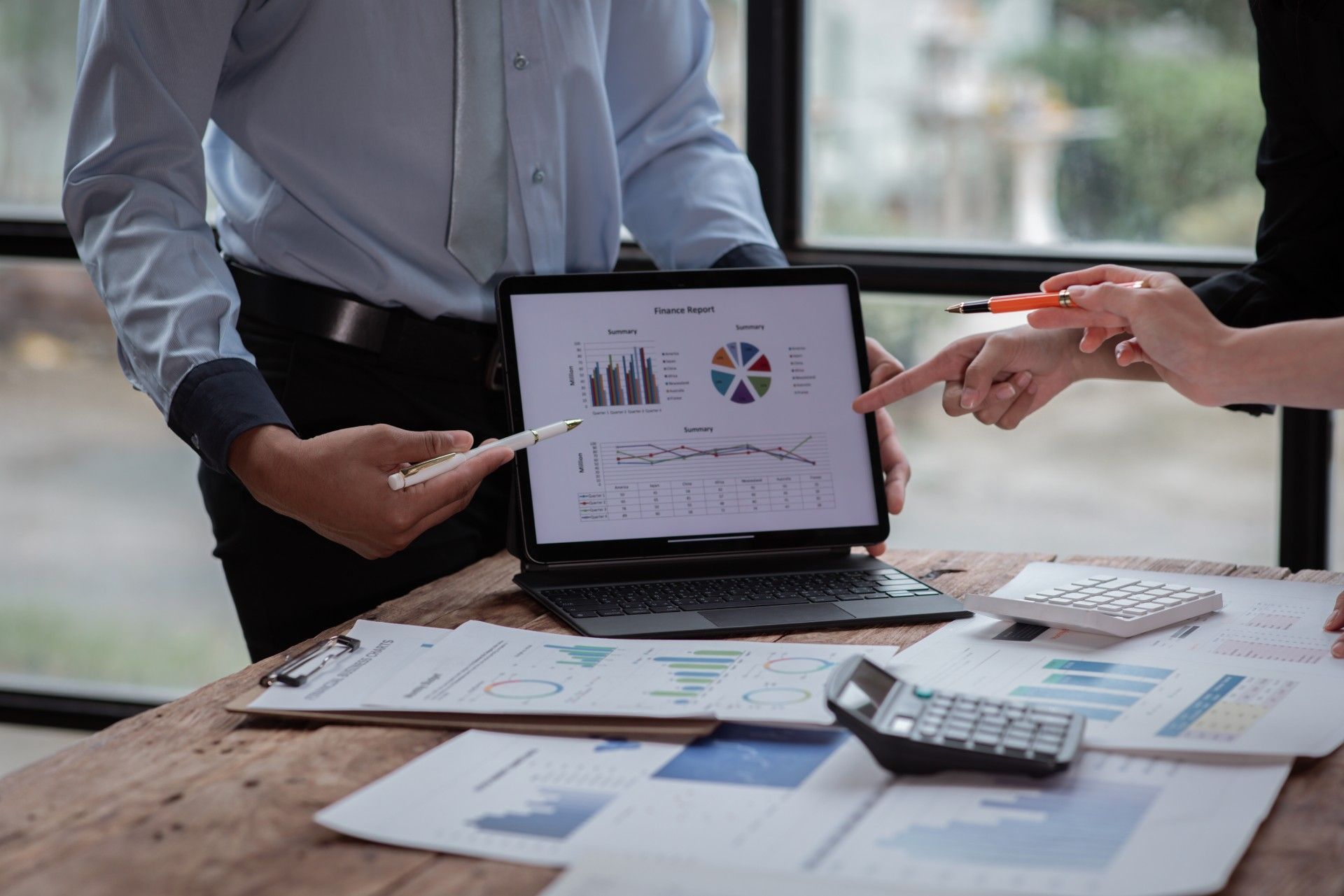 A man and a woman are looking at a laptop computer.