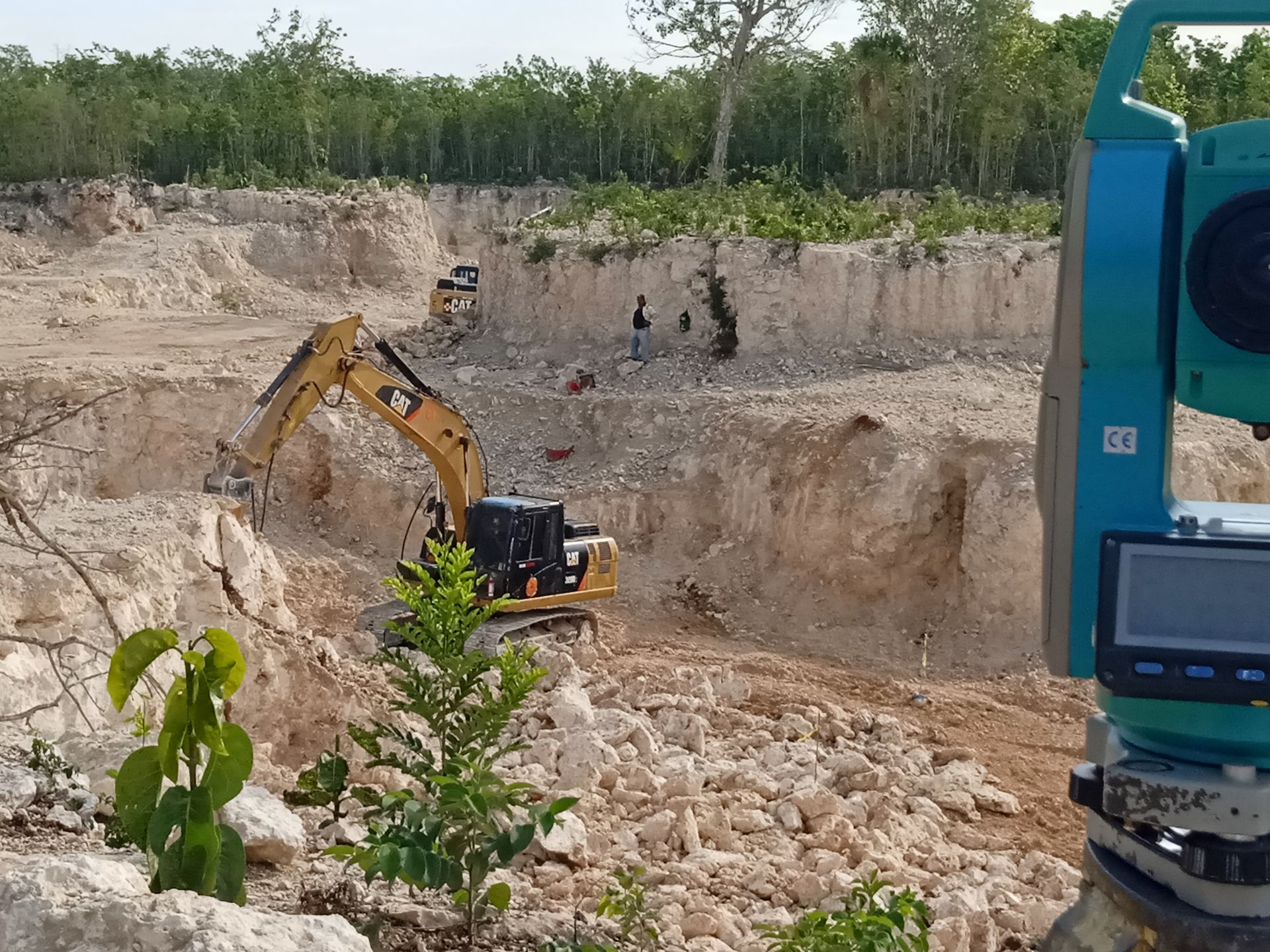 Una excavadora está cavando un hoyo en un campo de tierra.
