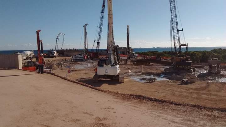 Una obra en construcción con mucha maquinaria y grúas.