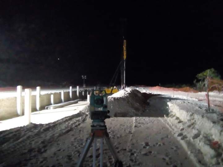 Una cámara está en un trípode en la nieve por la noche.