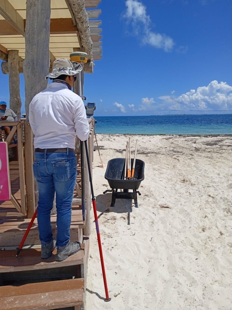 Un hombre está parado en una playa mirando el océano.