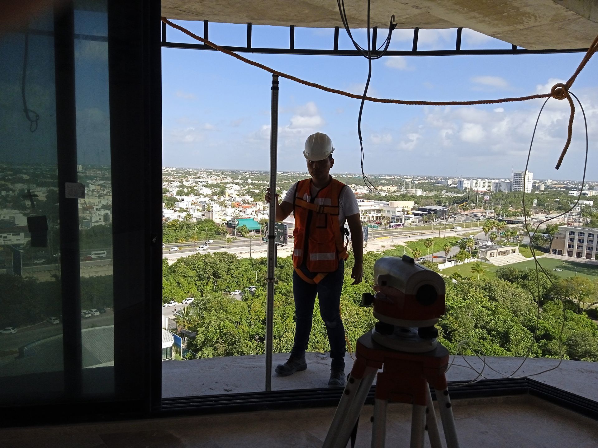 Un hombre está parado en la cima de un edificio mirando por una ventana.