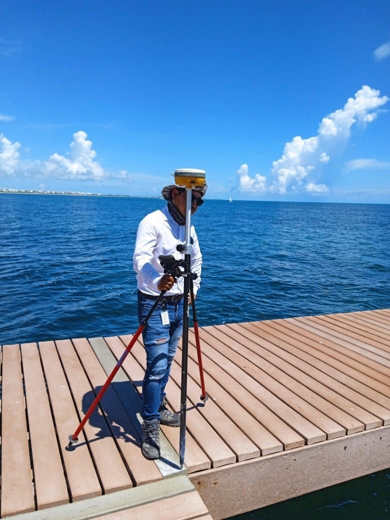 Un hombre está parado en un muelle cerca del océano.