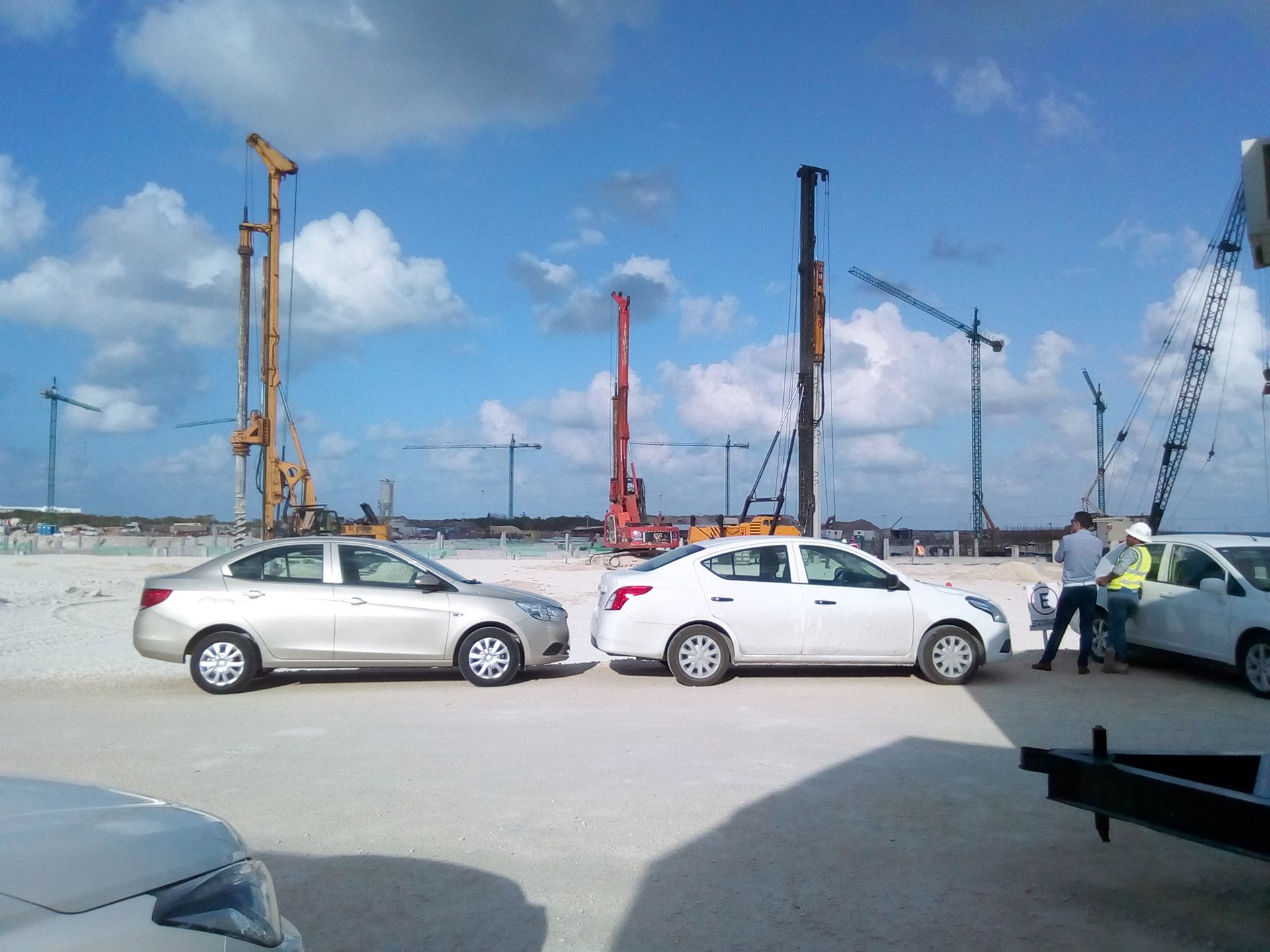 Dos coches están aparcados uno al lado del otro en una obra en construcción