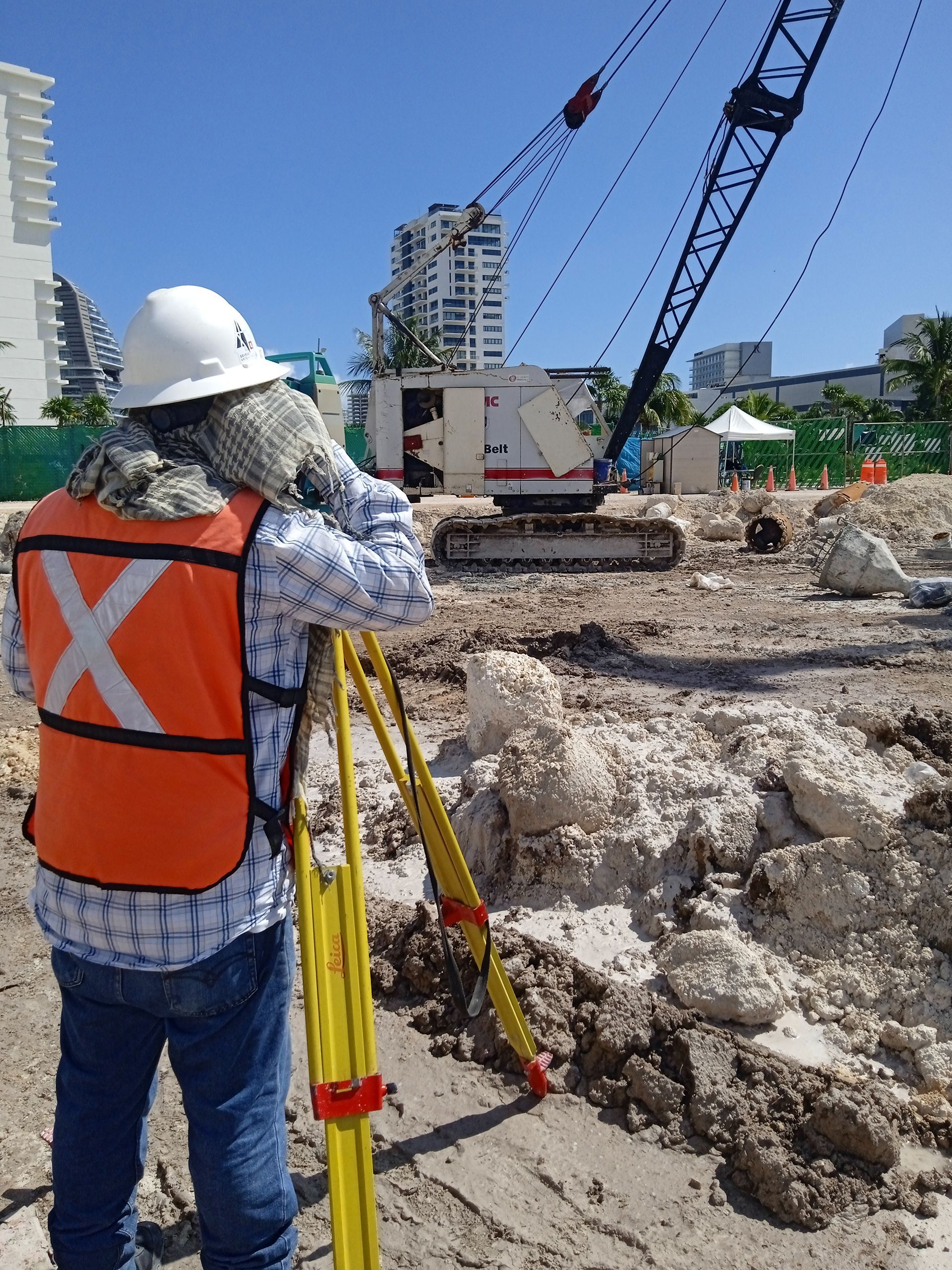 Un trabajador de la construcción que lleva un chaleco naranja con una x en él.