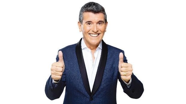 Un hombre con un traje azul está haciendo dos pulgares hacia arriba.