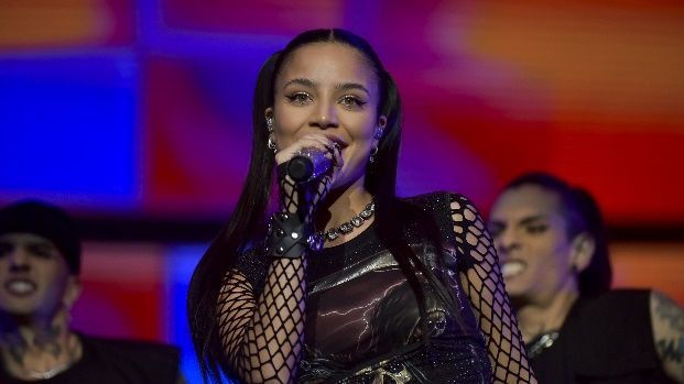 Una mujer está cantando en un micrófono en un escenario.