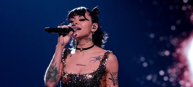 Una mujer está cantando en un micrófono en un escenario.