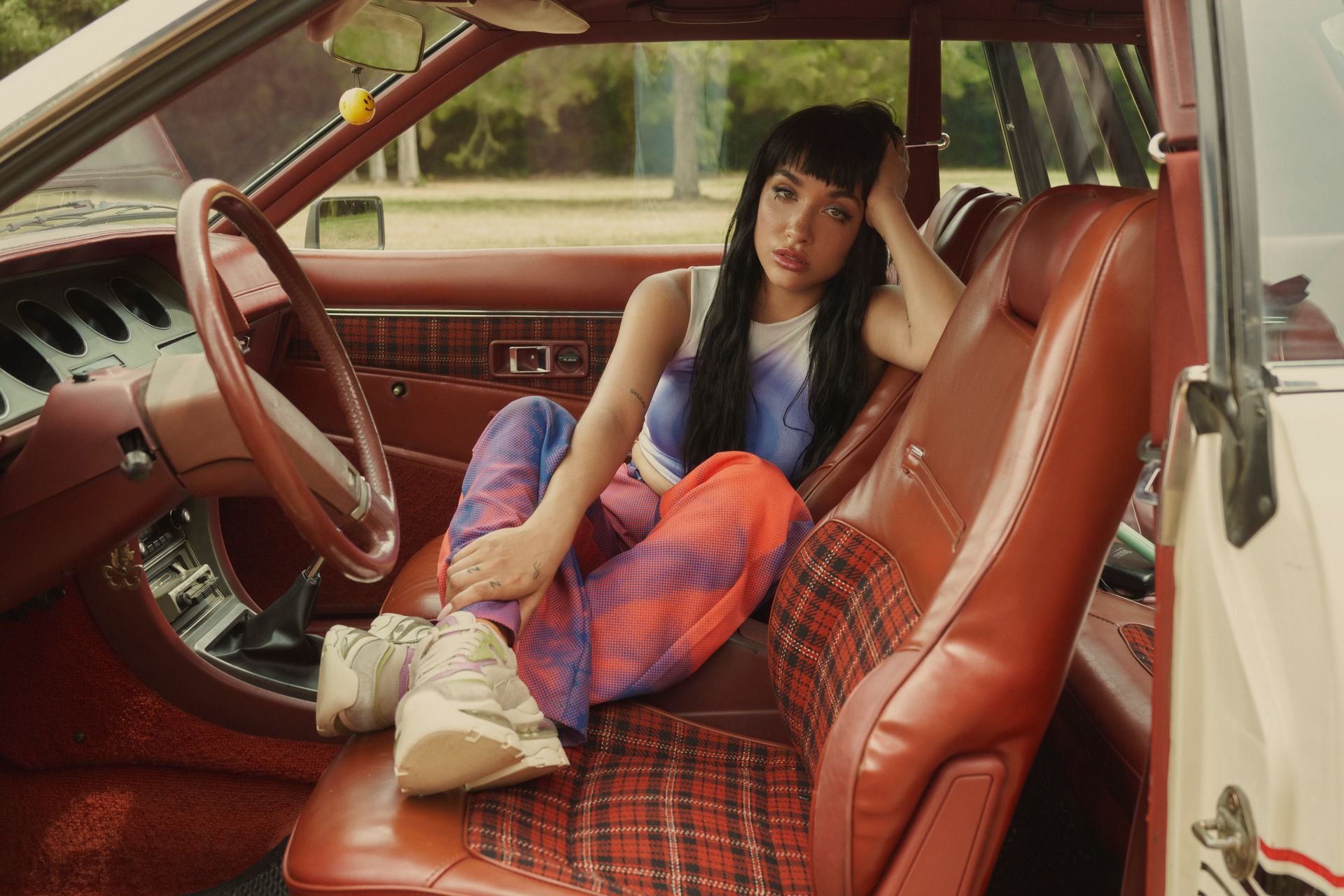 Una mujer está sentada en el asiento trasero de un coche.