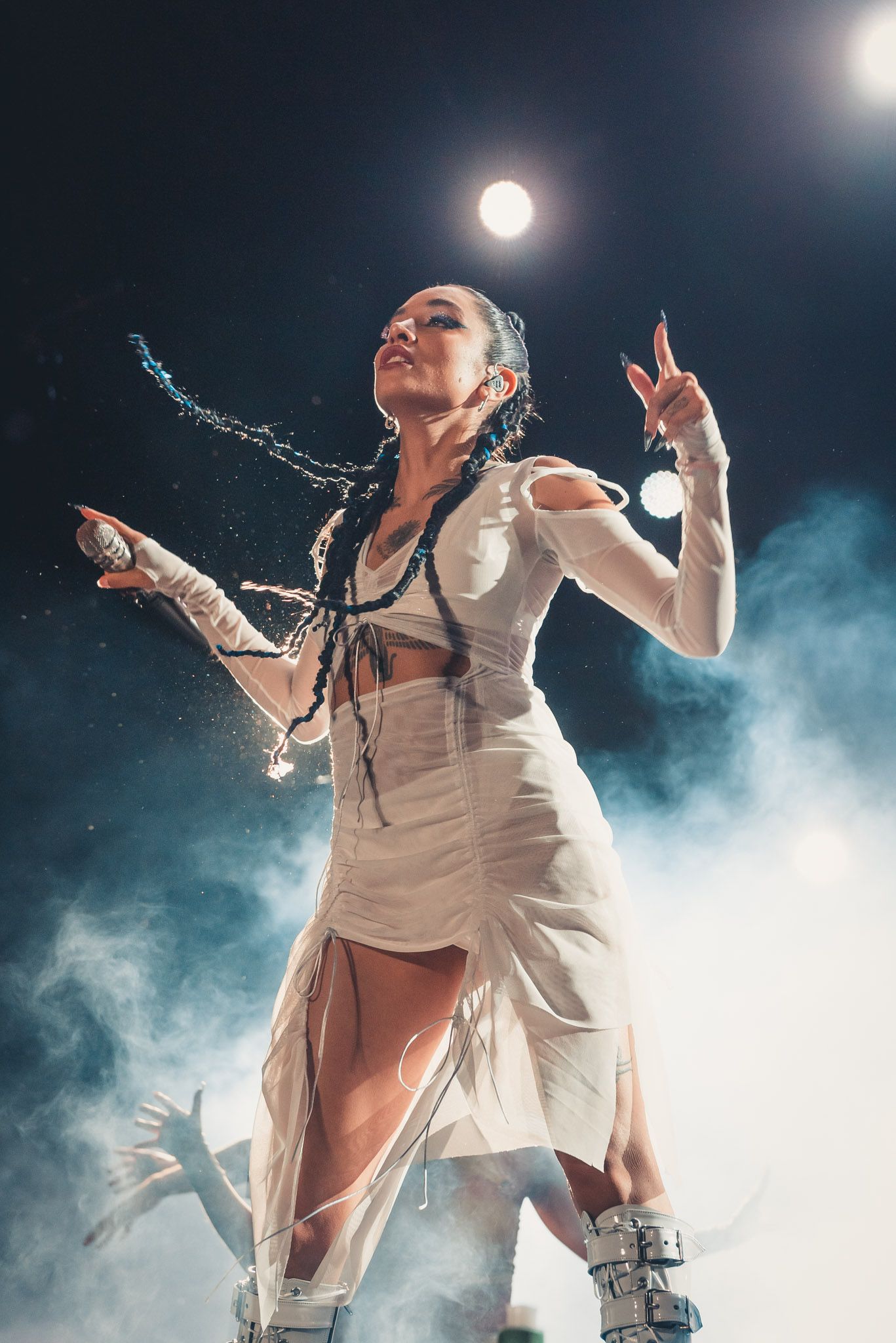 Una mujer con un vestido blanco está de pie en un escenario.