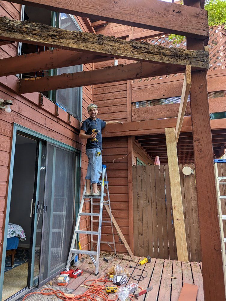 Dark green and coral floral wallpaper in a bathroom corner, with dark green wainscoting and a gold mirror.