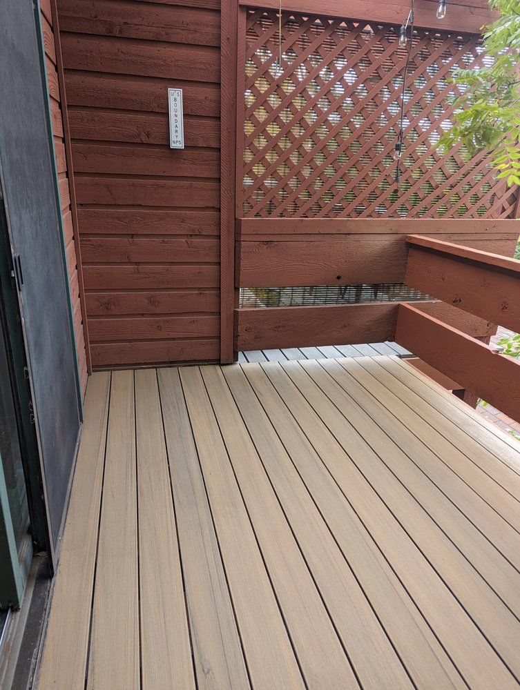 Two electricians working on an electrical panel outside a building. One holds a cable.
