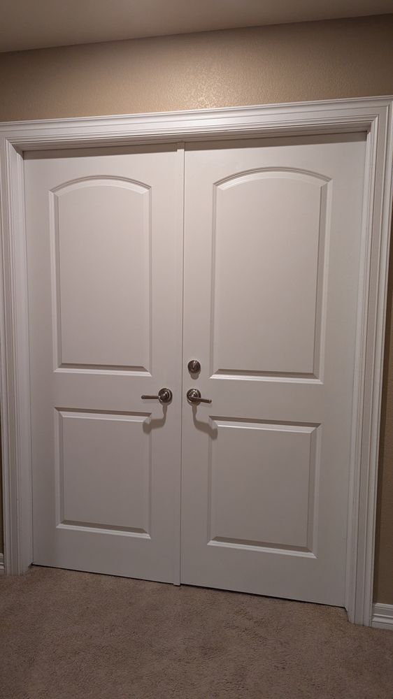 Trench dug in a grassy yard, leading to a house with black siding, and an electrical box.