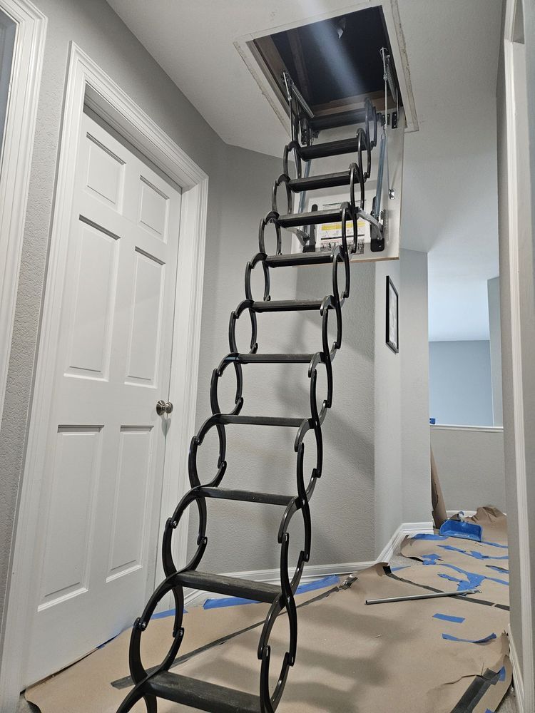 Two electricians working on an electrical panel outside a building. One holds a cable.