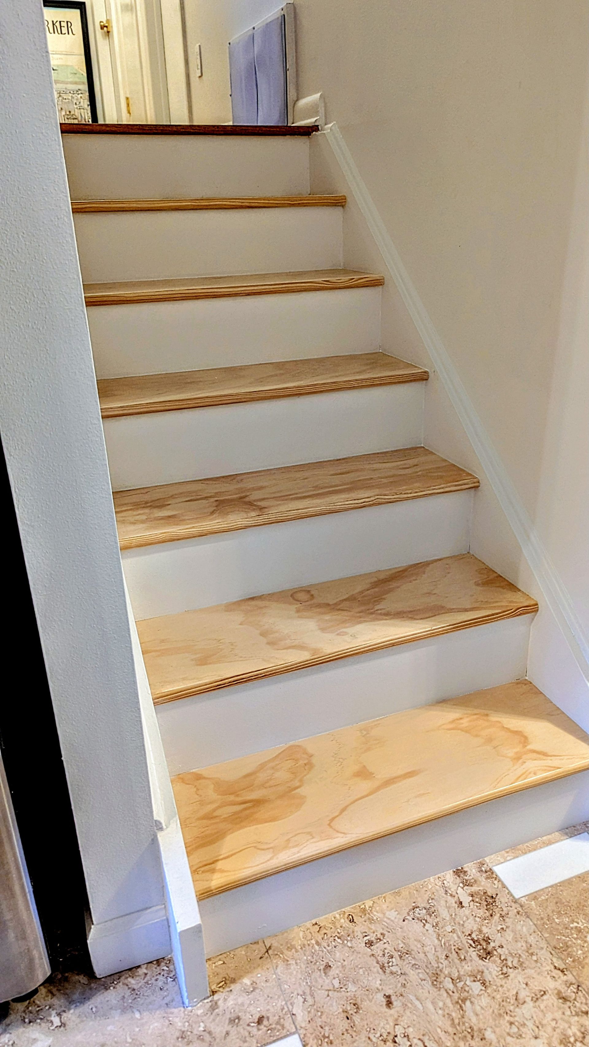 Staircase with light-colored plywood treads and white risers. Stairs ascend, leading to an upper level.