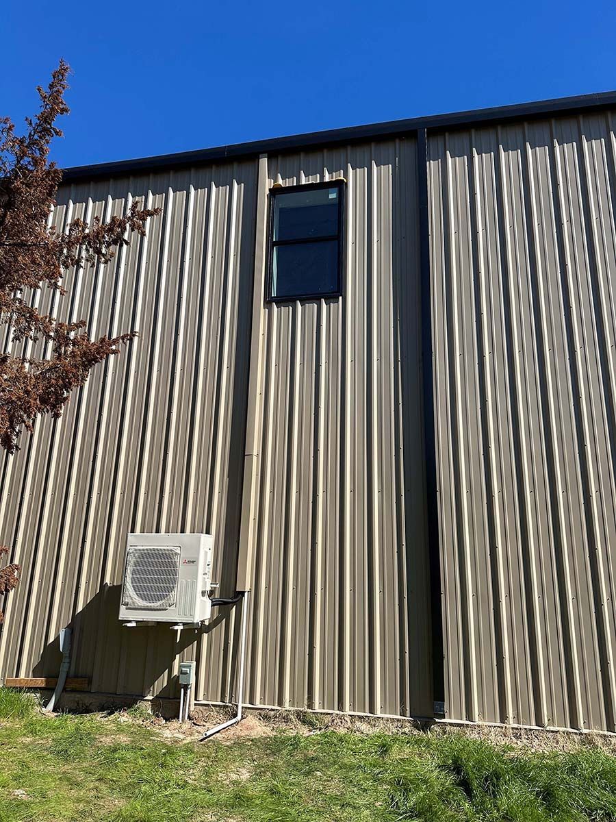 A building with a window and a fan on the side of it.