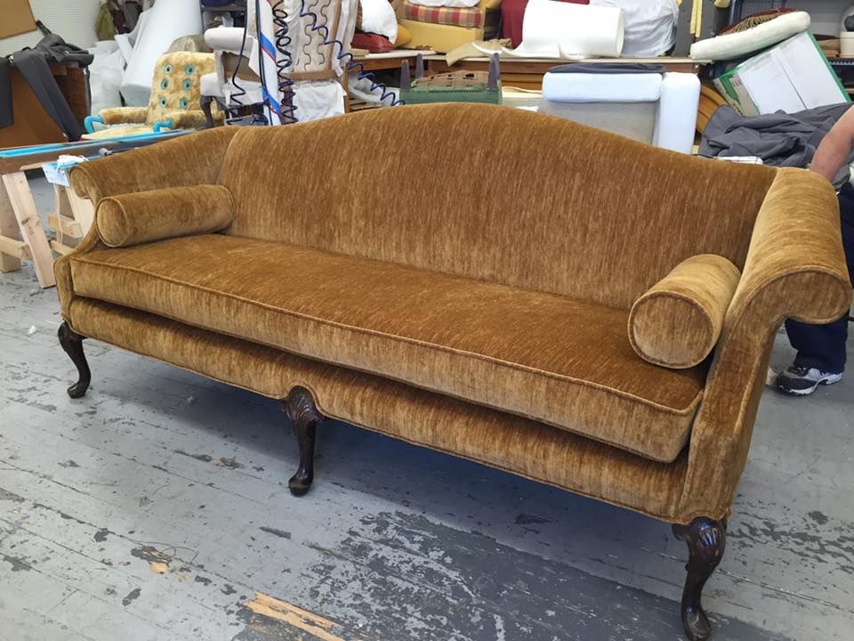 A brown couch is sitting on the floor in a room