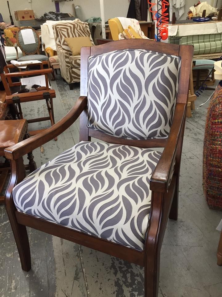 A chair with a gray and white pattern on it is sitting in a room.