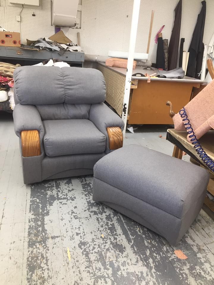 A grey chair and ottoman are in a room