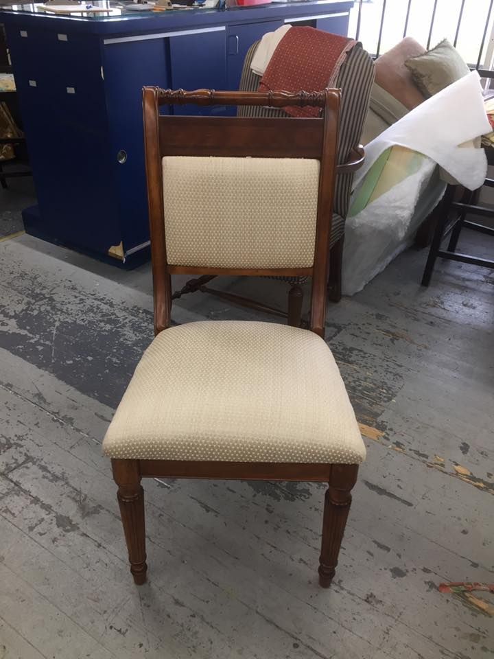 A chair with a white seat is sitting in a room.