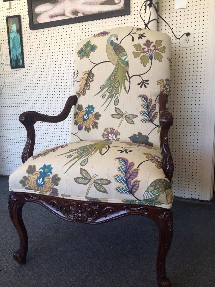A chair with a peacock and flowers on it