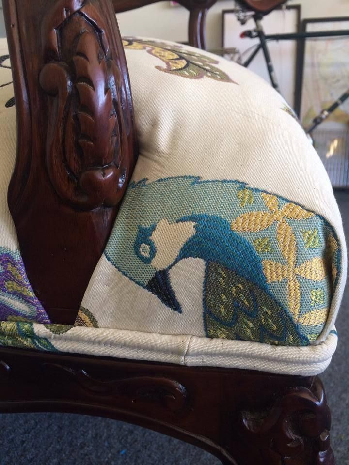 A chair with a peacock embroidered on it
