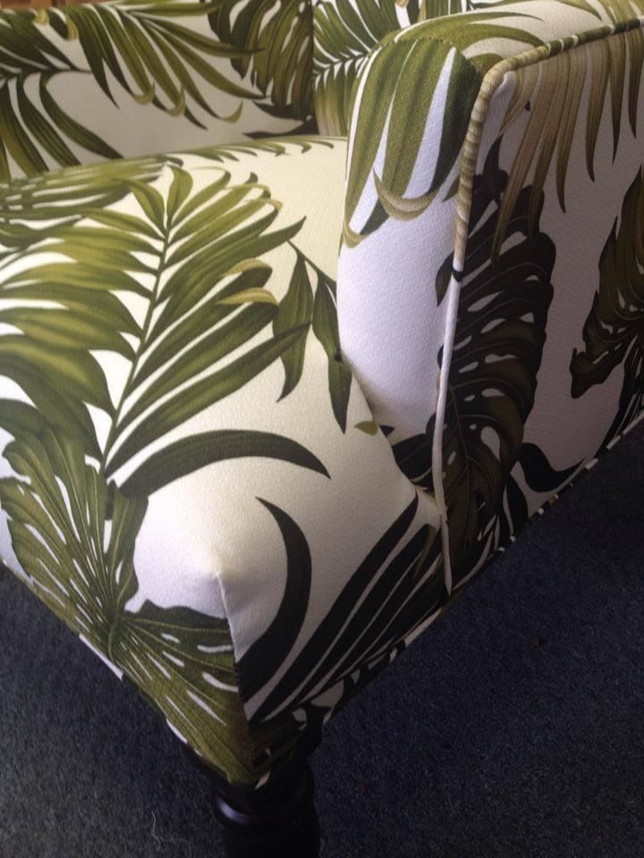A green and white chair with leaves on it