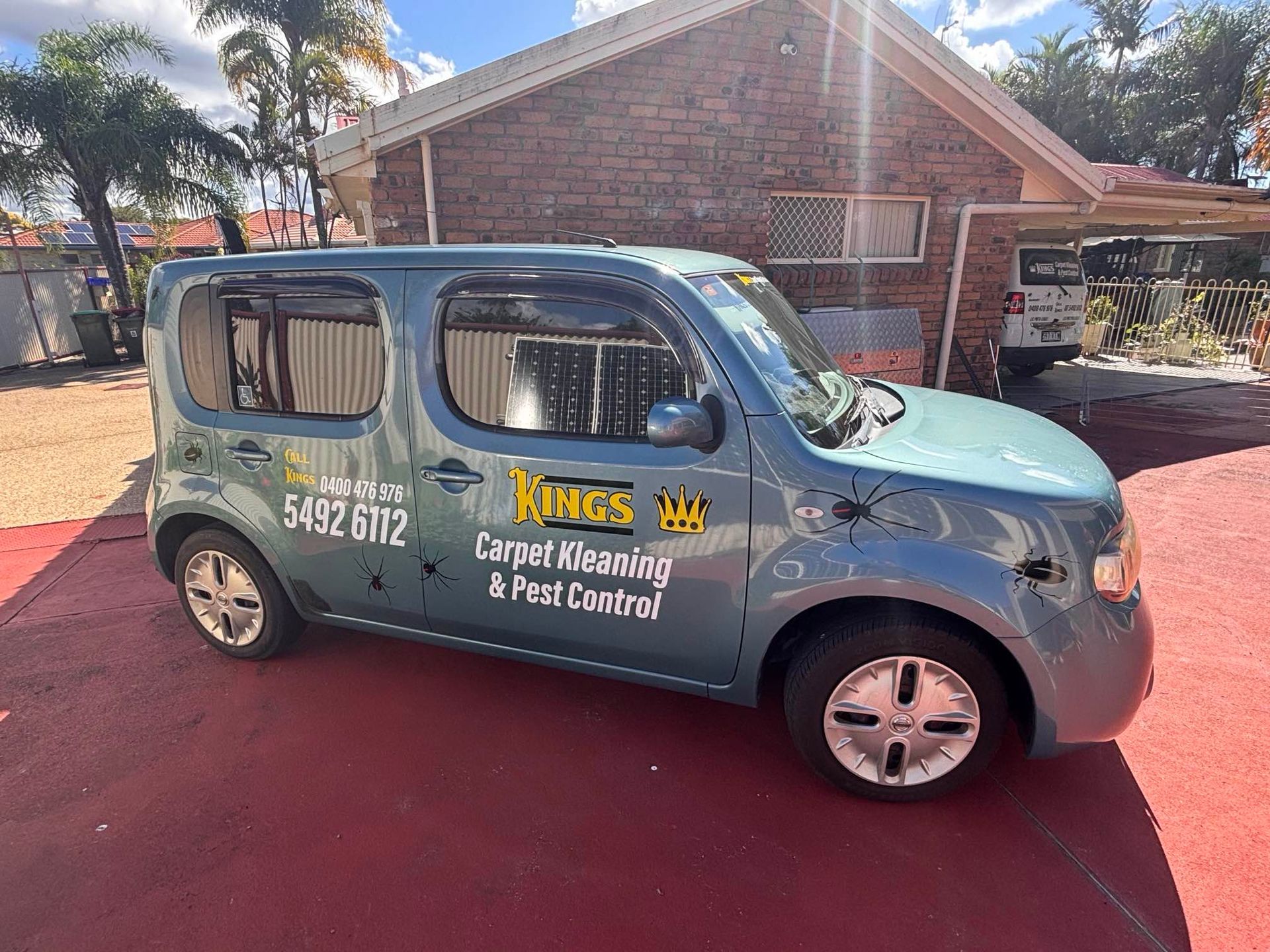 A Blue Van is Parked in Front of a Brick House — King's John Carpet Kleaning & Pest Control In Kawana Waters, QLD