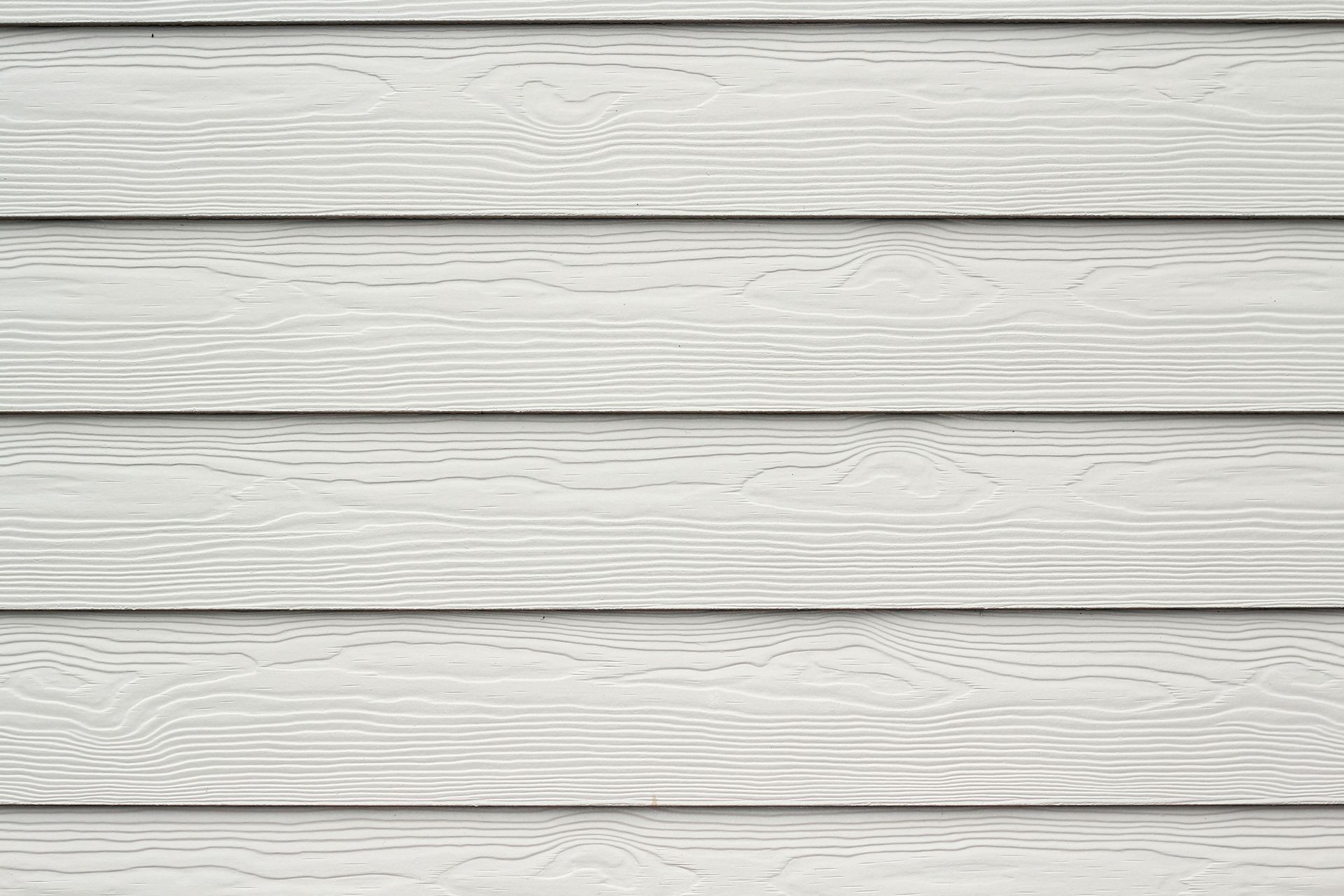 Revêtement blanc avec texture de grain de bois horizontal sur un mur extérieur.