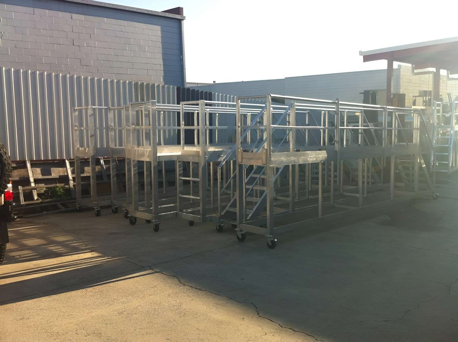 Several Metal Platforms With Railings And Wheels, Parked Outside A Building