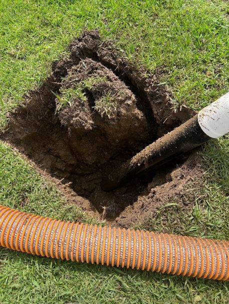 A Hose Is Being Used To Pump Dirt Into A Hole In The Ground — MCR Hydro Excavations & VAC Truck Services In Belmore River, NSW