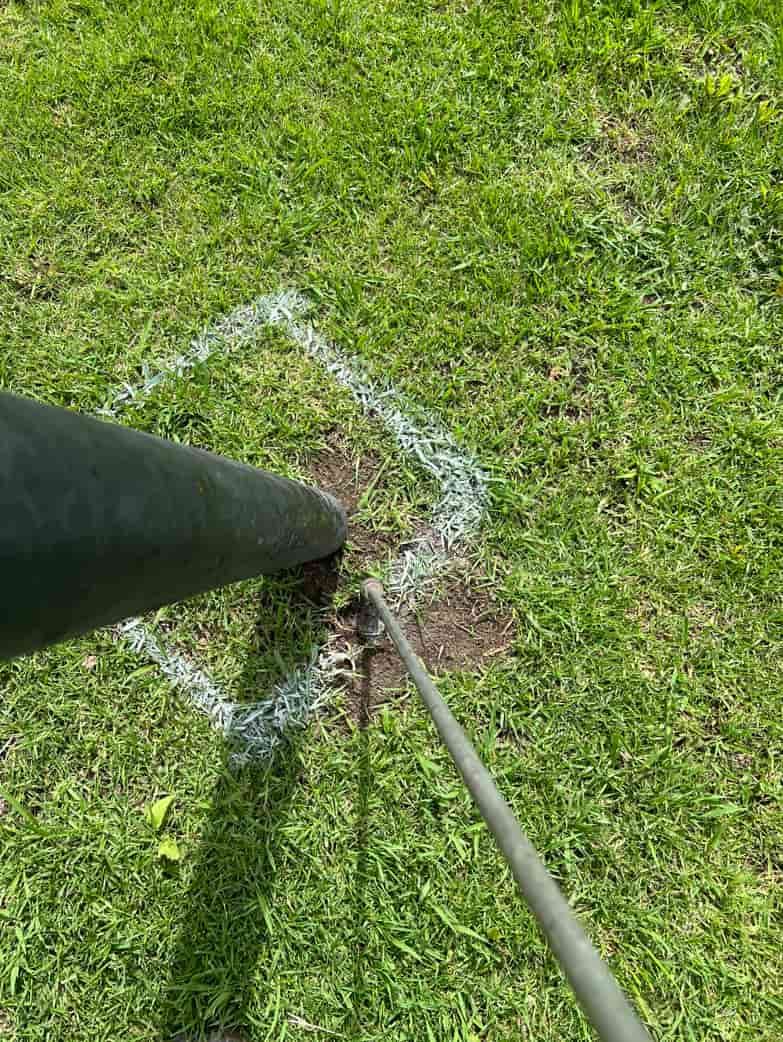 A Person Is Standing Next To A Pole In The Grass — MCR Hydro Excavations & VAC Truck Services In Belmore River, NSW