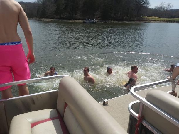 Dirty Duck Boat Rentals | Lake of the Ozarks a group of people are swimming in a lake on a pontoon boat