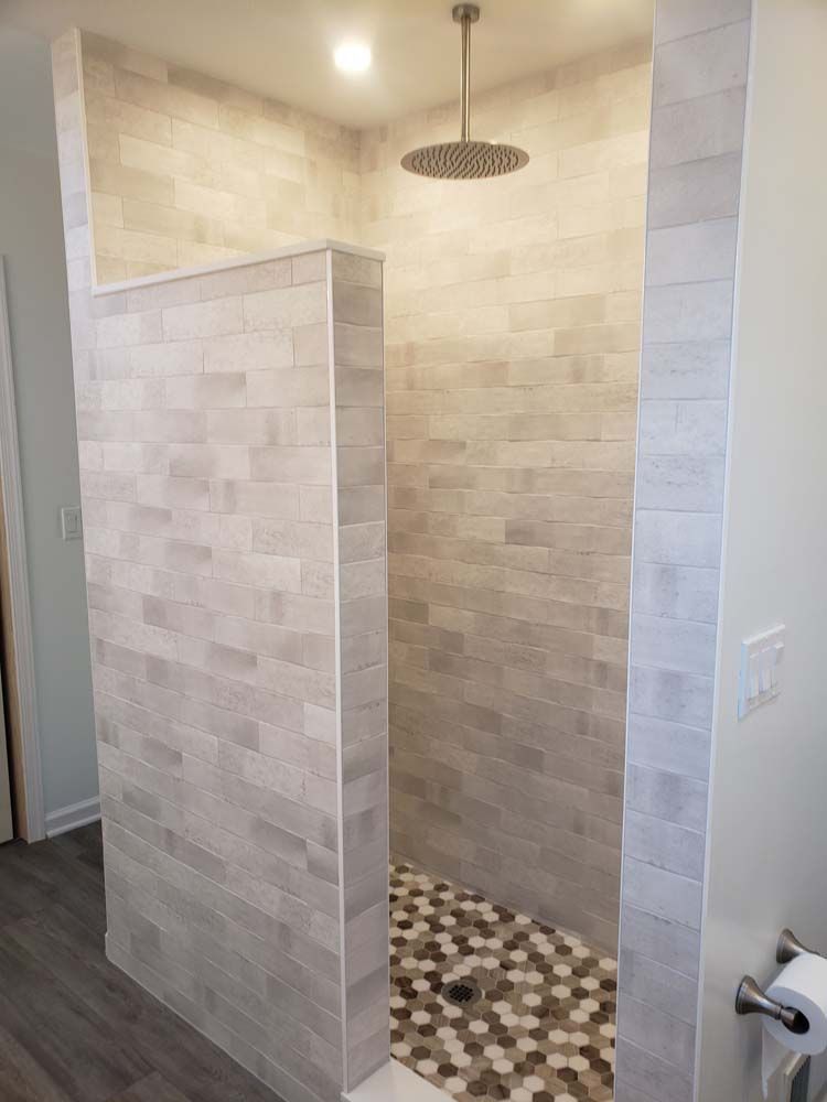 A bathroom with a walk in shower and a shower head.