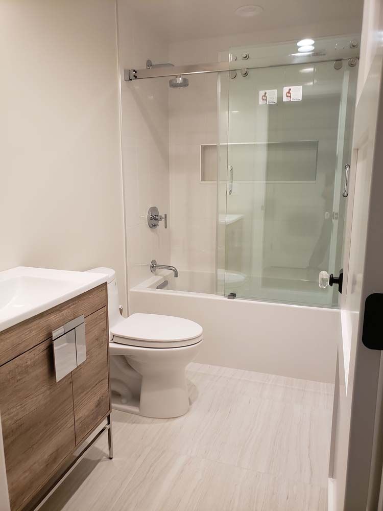 A bathroom with a toilet , sink , bathtub and shower.