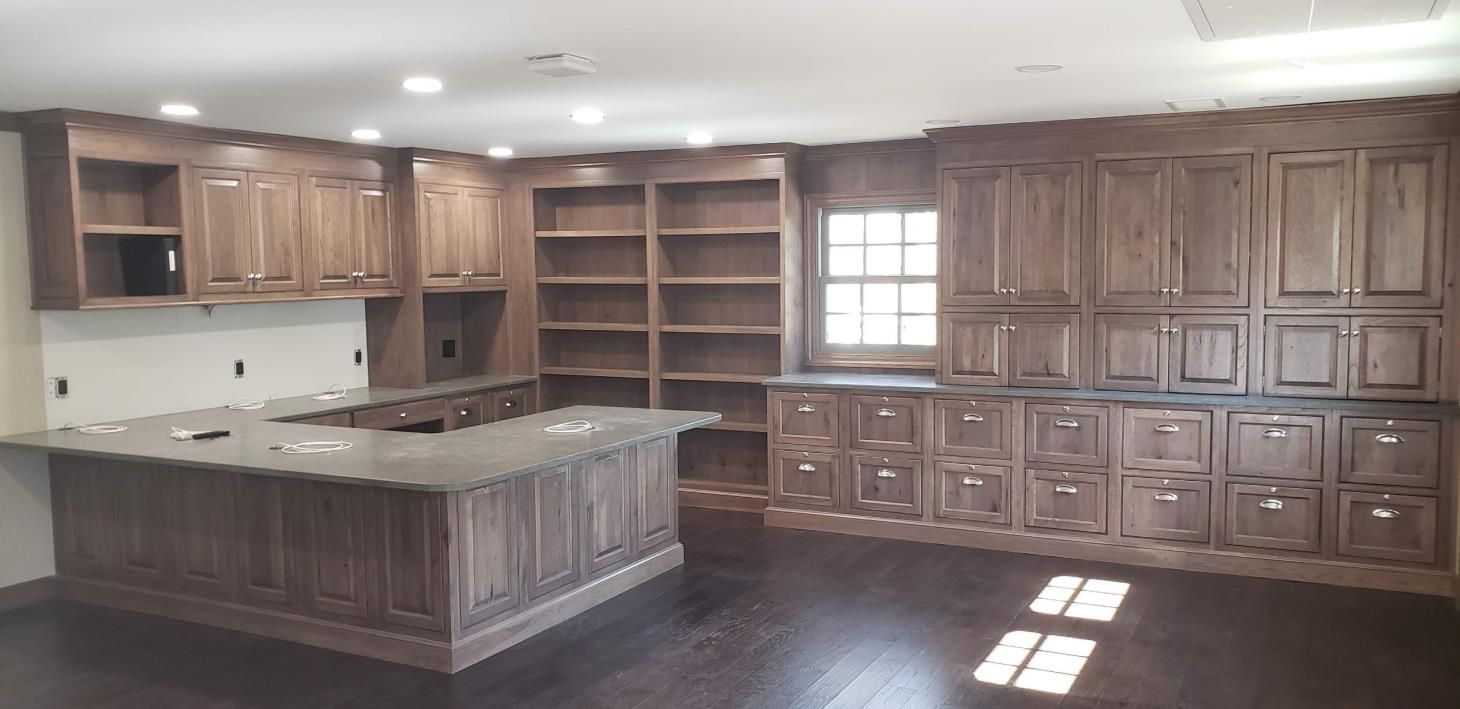 A kitchen with wooden cabinets , granite counter tops , and a large island.