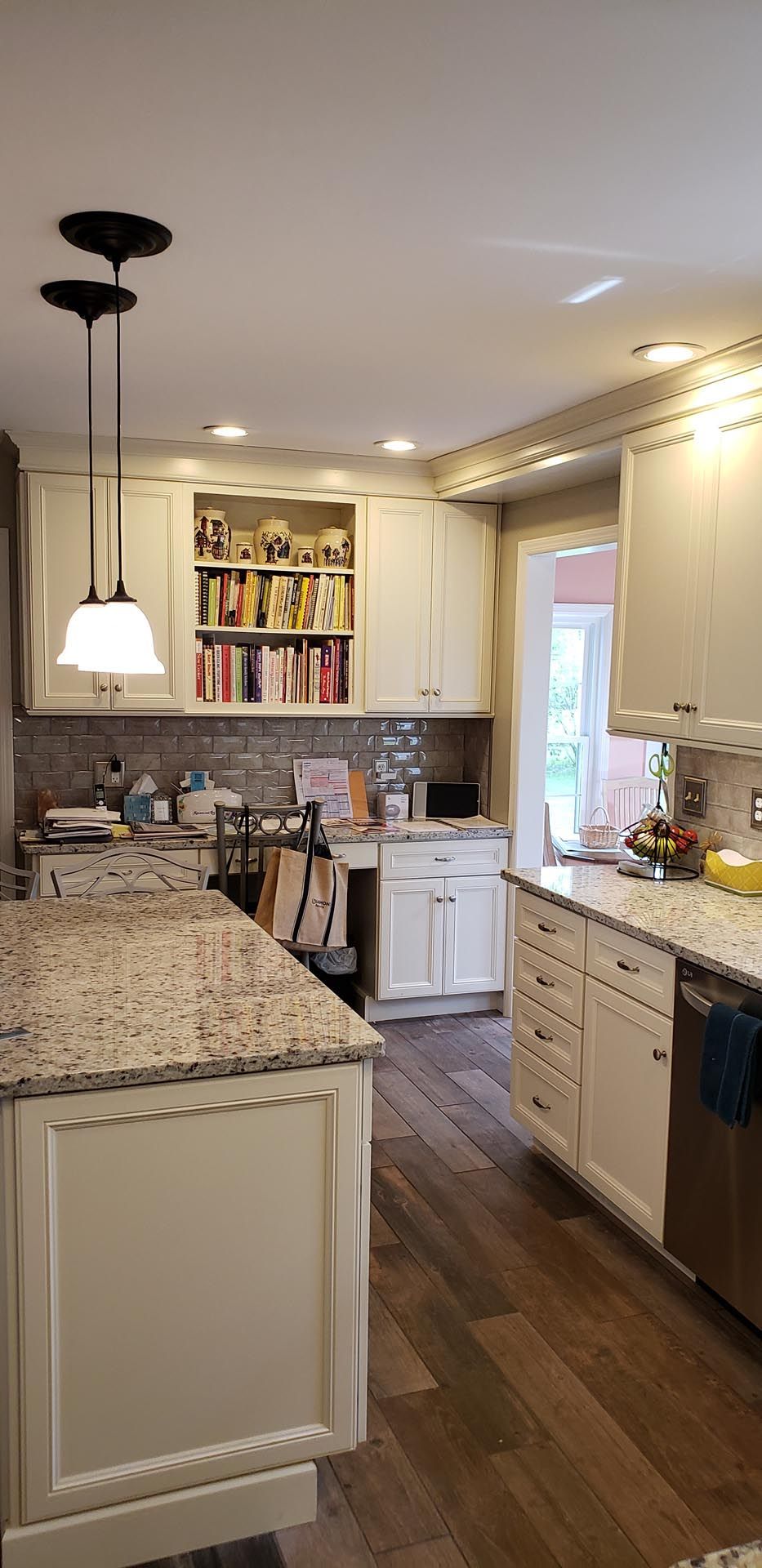 A kitchen with white cabinets and granite counter tops.