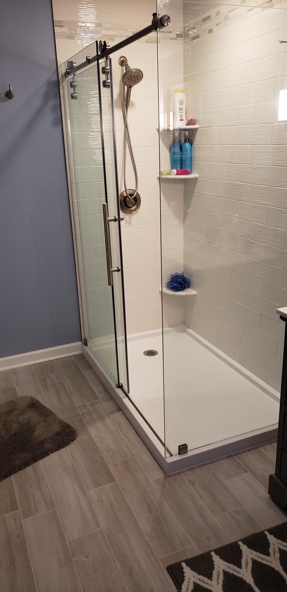 A bathroom with a walk in shower with sliding glass doors.