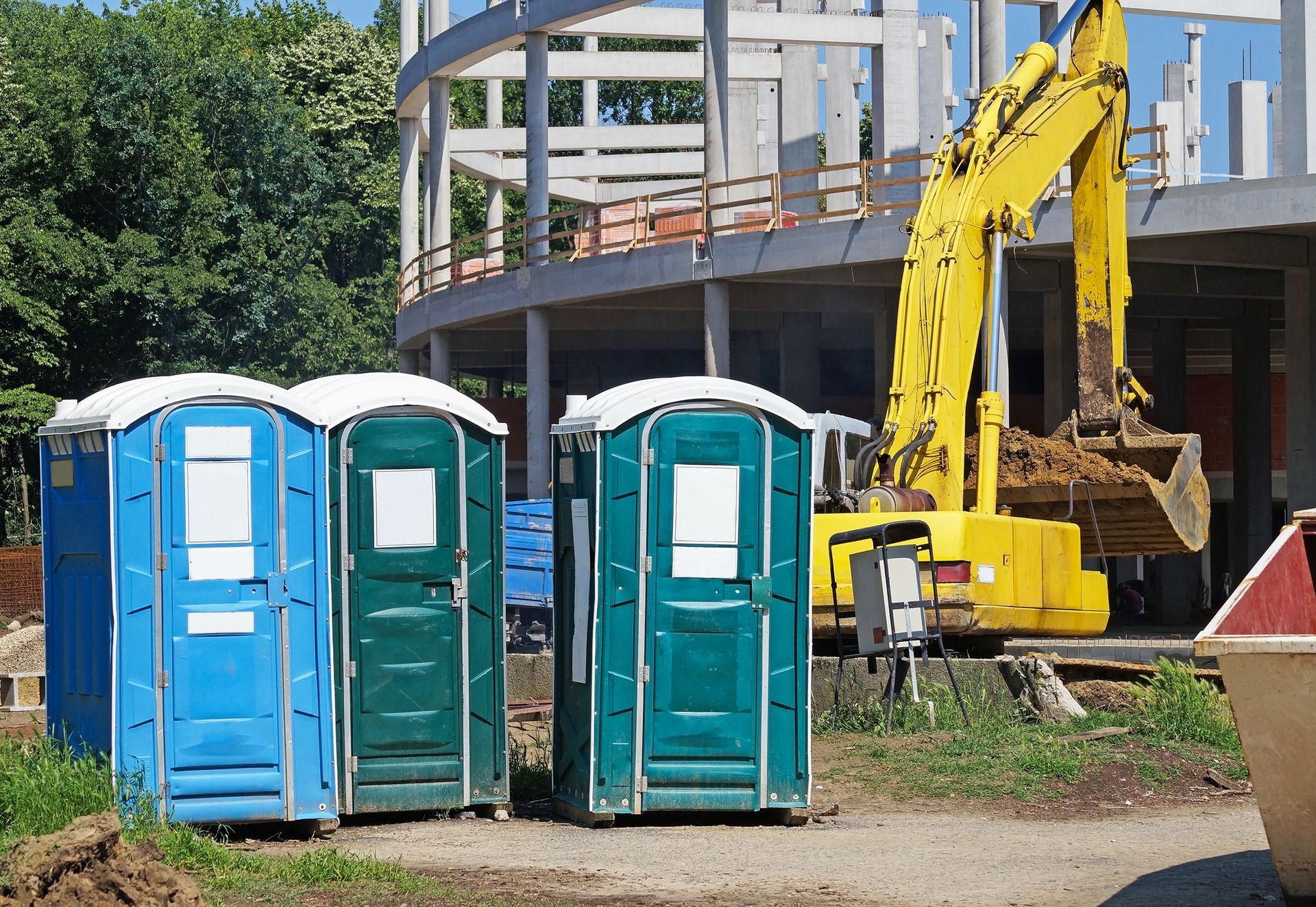Portable restroom units at a busy construction site for worker convenience.