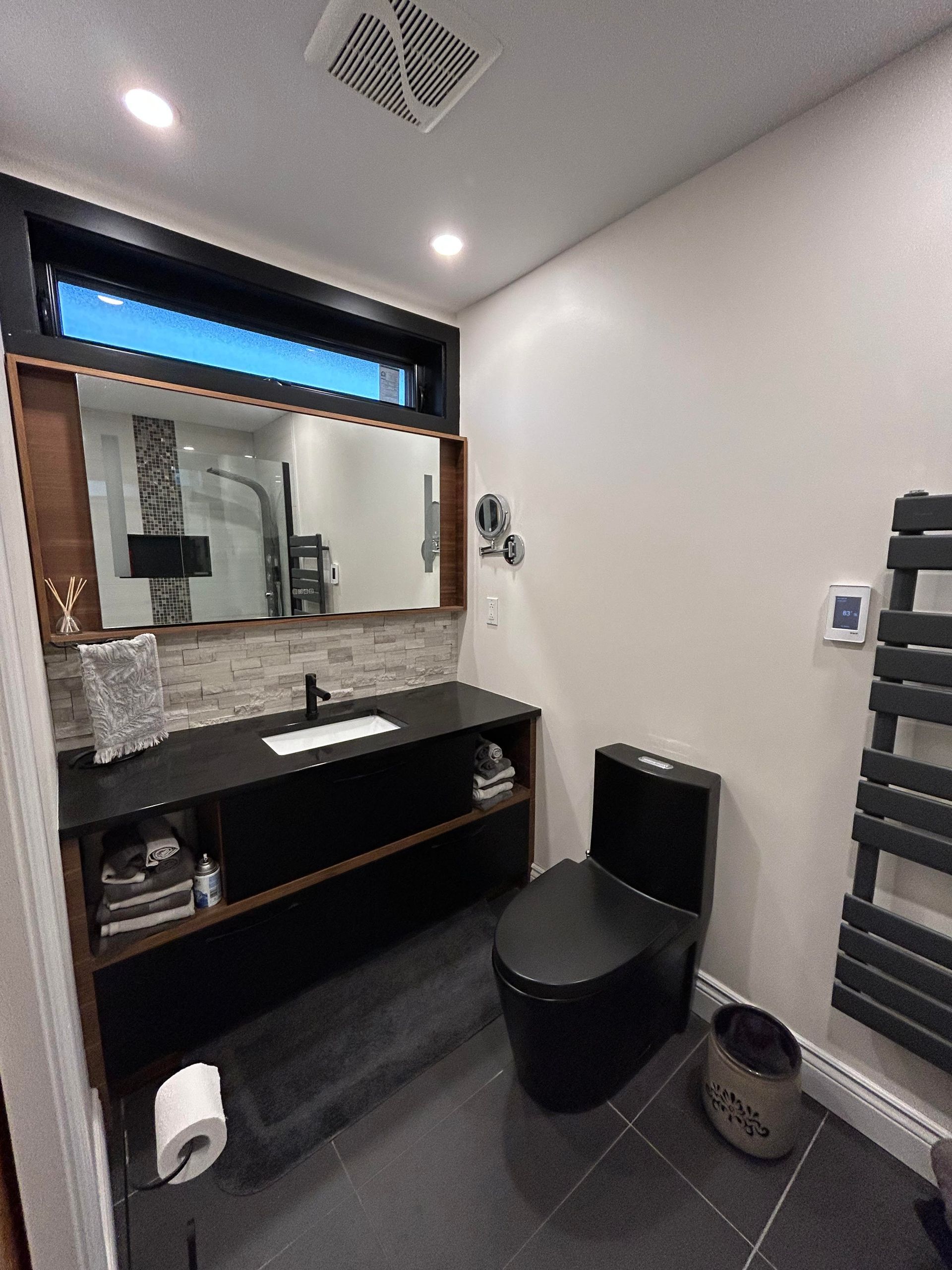 Une salle de bain avec WC, lavabo et miroir.