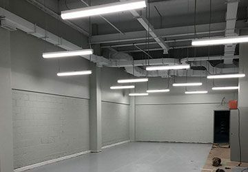 Une grande pièce vide avec beaucoup de lumières suspendues au plafond.