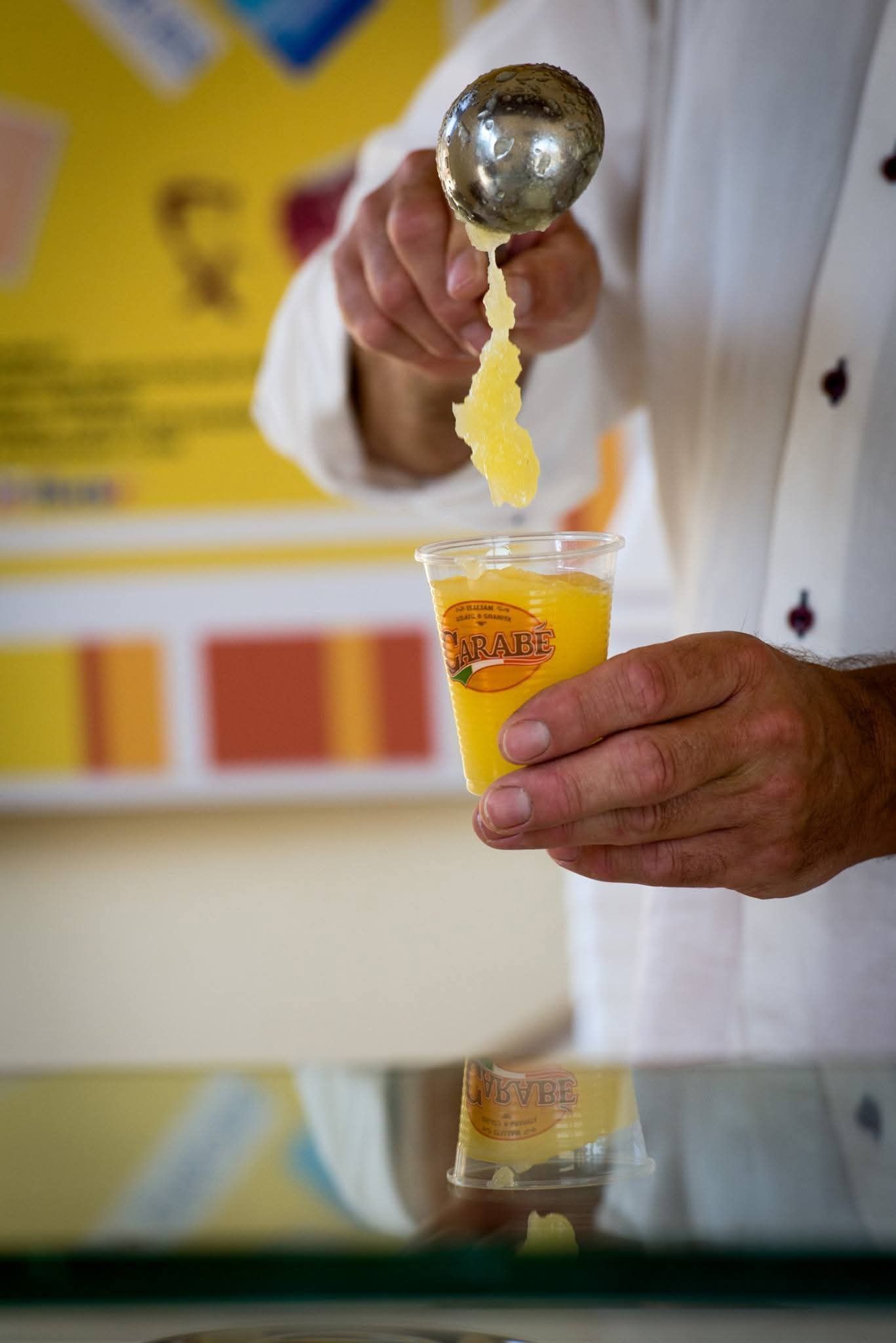 Un uomo in camice bianco sta versando il gelato in una tazza